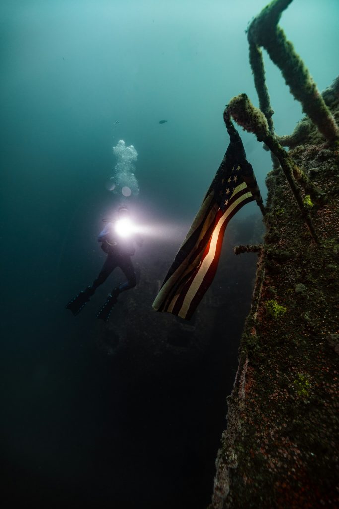 Scuba diver illuminating an object with a light underwater